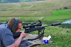 Long-Range-Schießen lernen mit der MINOX Academy Seitenansicht eines liegenden Schützen der mit einem Präzisionsgewehr mit taktischem Zielfernrohr MINOX ZP5 und Schalldämpfer auf ein Ziel in der Entfernung schießt.