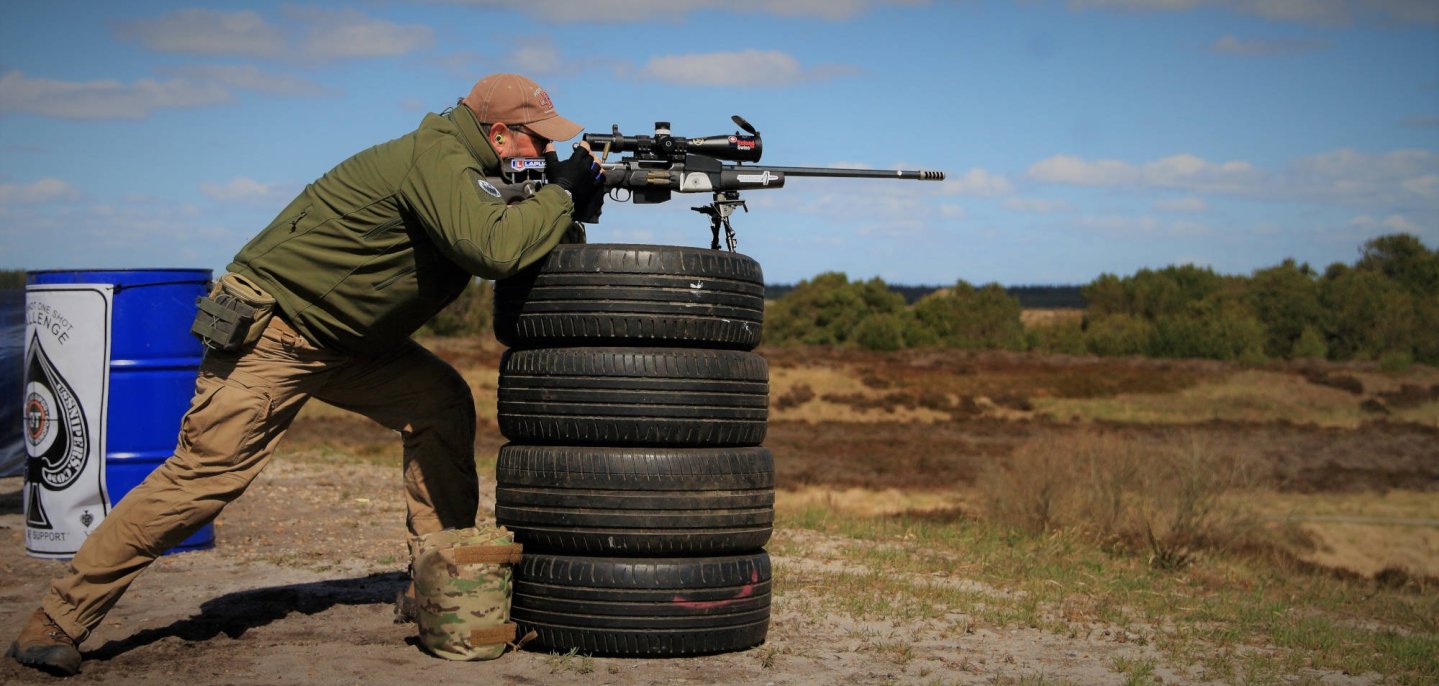 Practical Long Range (PLR) Competition in Dänemark Schütze schießt von Autoreifen.