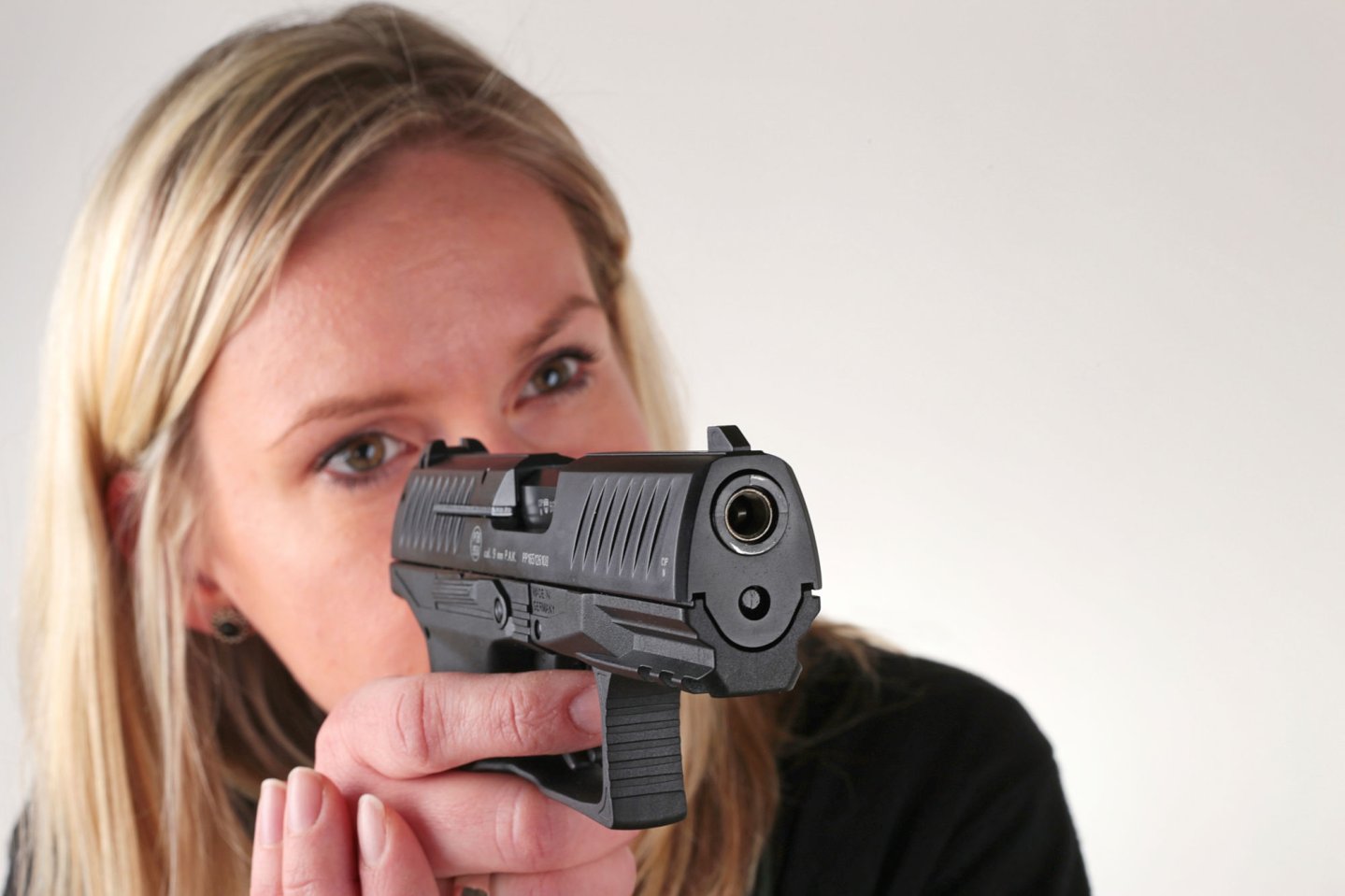 Übersicht Schreckschusswaffen: Gaswaffen in der Praxis und Kleiner Waffenschein Eine Frau hat eine Schreckschusspistole im Anschlag.