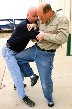 Selbstverteidigung und waffenlose Abwehr Teil 4 - Der Griff an den Kragen Mann stößt einem Angreifer mit dem Knie in die Leistengegend.