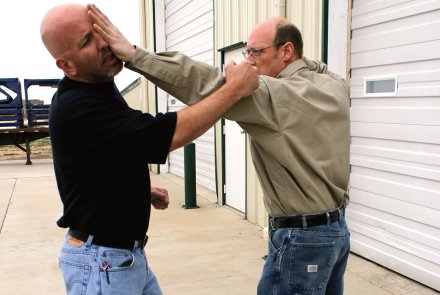 Selbstverteidigung und waffenlose Abwehr Teil 4 - Der Griff an den Kragen Mann wehrt Angreifer mit Handflächenstoß zum Kopf ab.