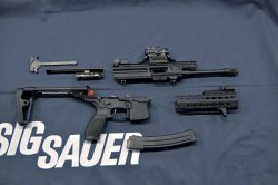 In ihre Hauptbestandteile zerlegte MPX-Maschinenpistole. Wie das MCX-Sturmgewehr ein Gasdrucklader mit Drehkopfverschluss mit sieben Verriegelungswarzen. Bei beiden Waffen stammen die transparenten Magazine mit Kapazität für 30 Patronen übrigens von der US-Firma Lancer Systems. Modulare Maschinenpistole SIG Sauer MPX in Einzelteile zerlegt
