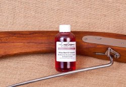 Waffenpflege und Zubehör für Vorderladerschützen – welche Produkte produziert ARTAX Vorderlader? ARTAX Red Oil vor Holzschaft