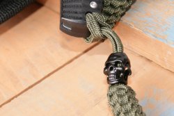 Premiere bei PohlForce: Force Three Outdoor und Force Four Outdoor Dieser schwarze Totenkopf ist die Halteöse am Fangriemen der PohlForce Force Three und Force Four-Klappmesser.