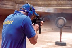 caliber 7+8/2016 Ein caliber-Tester in blauer Kleidung mit der Heckler & Koch SP 5 K auf dem Schießstand.