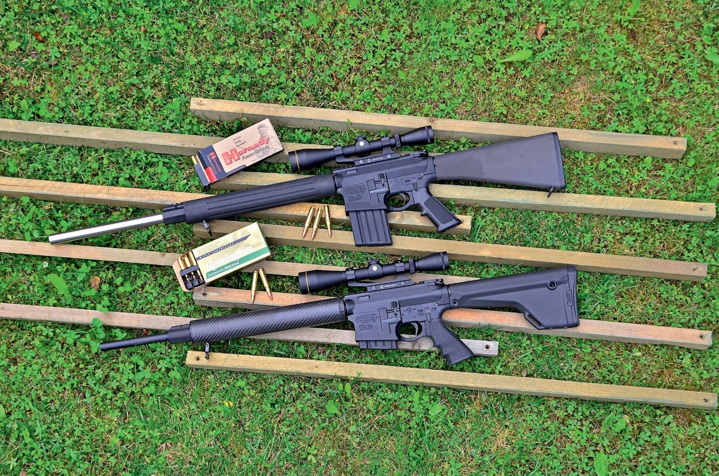 DPMS G2 B24 (oben) und DPMS G2 Hunter (unten) auf Holzbrettern auf einem Rasen.