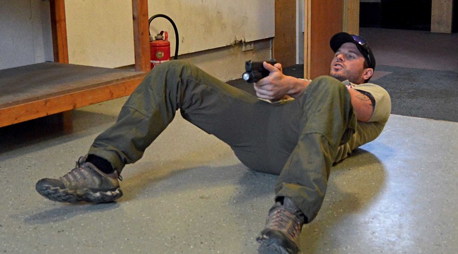 Schütze liegt auf dem Rücken und zielt.