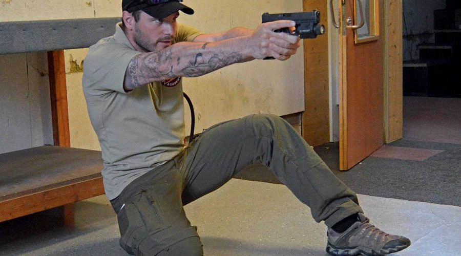 Schütze kniet und hat eine Pistole im Anschlag.