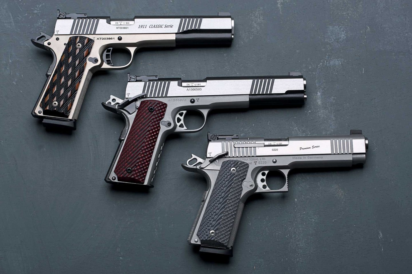 caliber 11+12/2016 Drei 1911er-Pistolen von RBF in rechter Seitenansicht auf schwarzem Untergrund.