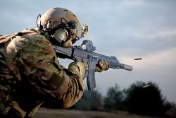 caliber 4/2017 Operator schießt die Heckler & Koch HK 433 vor Waldkulisse. Eine Hülse fliegt nach rechts weg.