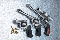caliber 4/2017 Ruger Super Redhawks in den Lauflängen 9,5", 7,5" und 2,5" (von oben) mit Munition in .44 Magnum auf Glasplatte.