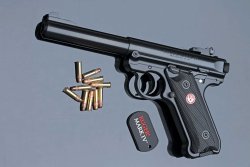 caliber 6/2017 Ruger Mark IV in linker Seitenansicht auf graublauem Hintergrund mit Kleinkaliber-Munition.