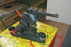 caliber 7+8/2018 Ransom Rest mit eingespannter P.08 auf bunter Platte.