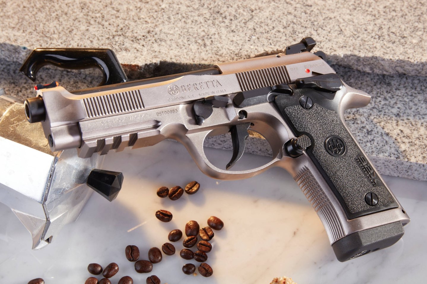 Revolver in rechter Seitenansicht an orange Feder gestützt.