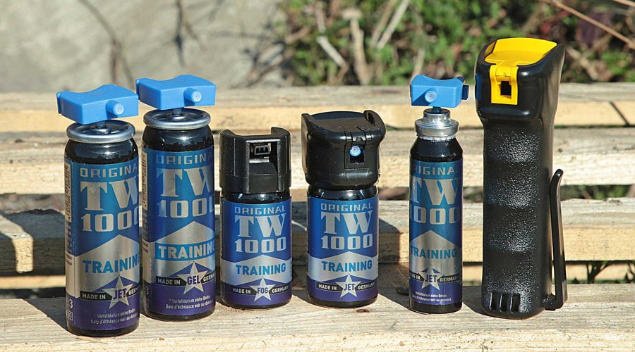 VISIER 5/2017: Mit Trainersprays wie dieser TW 1000-Reihe von Hoernecke lässt es sich realitätsnah üben. Trainersprays von TW100 in verschiedenen Größen und Ausführungen auf einer Holzbank.