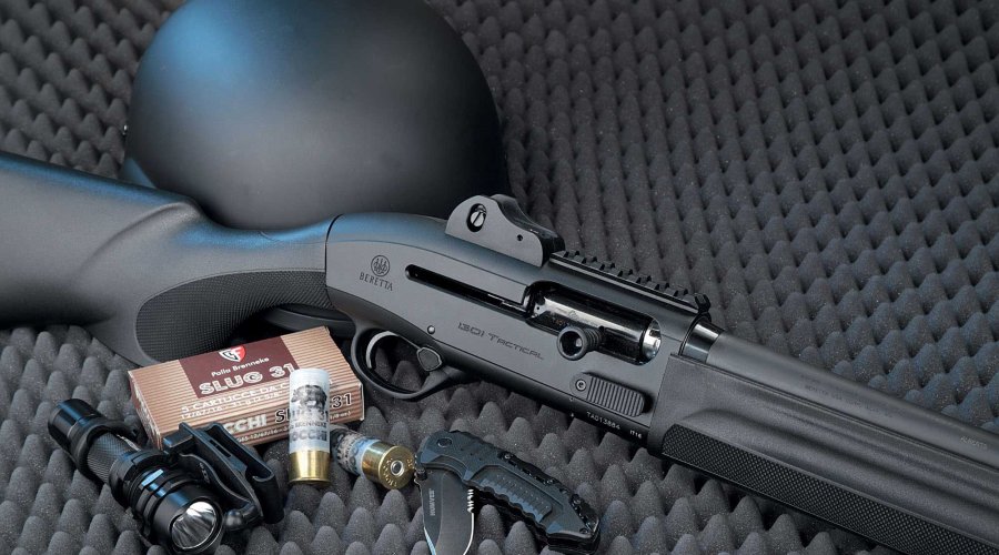 Beretta 1301 Tactical mit 12/76-Schrotpatronen, Messer, Taschenlampe und Helm auf grauem Schaumstoff.