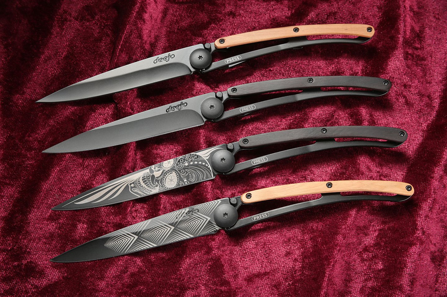 von oben: Deejo Black mit Wacholderholz, Deejo Black mit Grenadillholz, Deejo Black Tattoo Latin Skull, Deejo Black Tattoo Art Deco auf rotem Samt