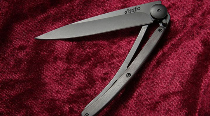 halbgeöffnetes Deejo Black mit Grenadillholz auf rotem Samt