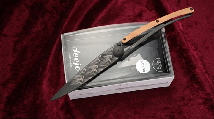 Deejo Black Tattoo Art Deco mit Wacholderholz, geöffnet auf Box auf rotem Samt