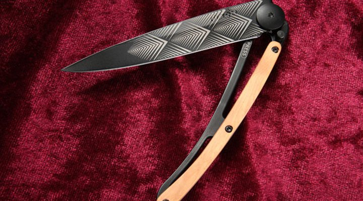 halbgeöffnetes Deejo Black Tattoo Art Deco mit Wacholderholz auf rotem Samt