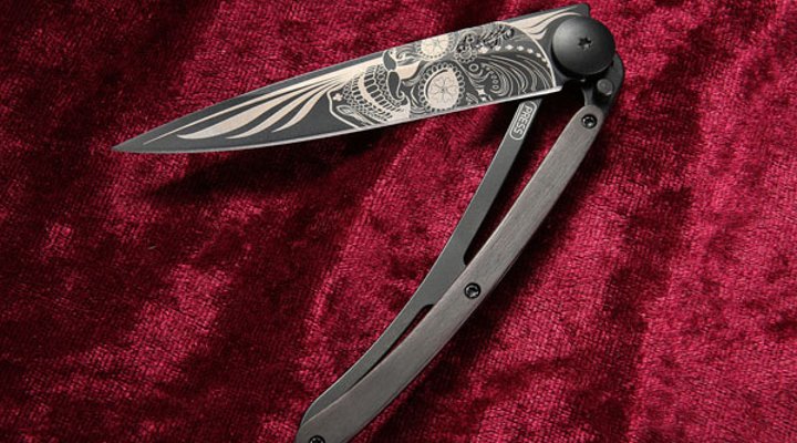 halbgeöffnetes Deejo Black Tattoo Latin Skull mit Grenadillholz auf rotem Samt