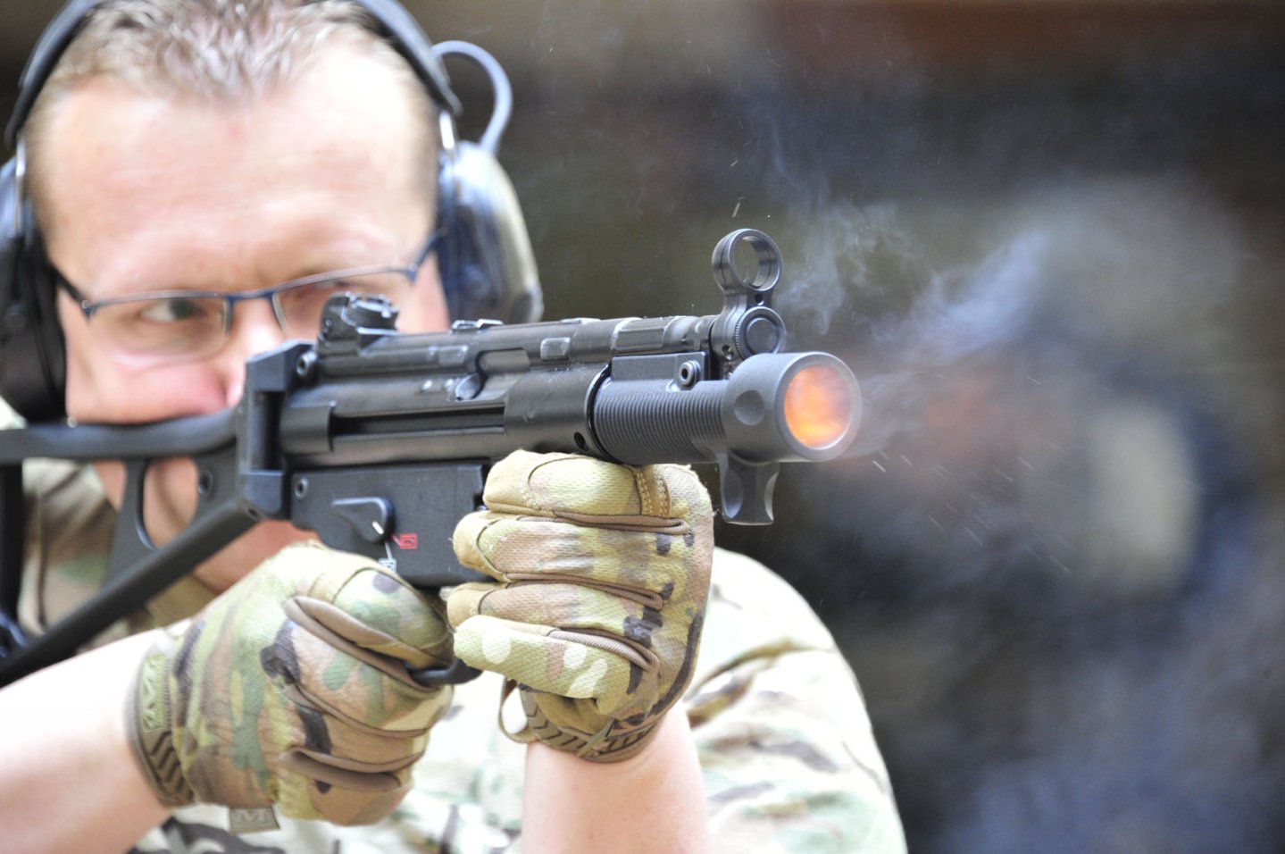 VISIER-Redakteur Alexander Losert mit der Heckler & Koch SP 5 K im Praxistest. Waffe von rechts vorne, im Schuss mit Feuer aus der Mündung.