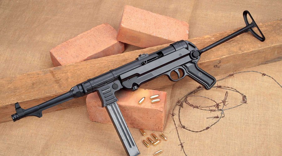 VISIER 11/2016 GSG MP 40 in linker Seitenansicht auf Holzbalken, Ziegeln und Stacheldraht mit 9 mm Luger-Munition.