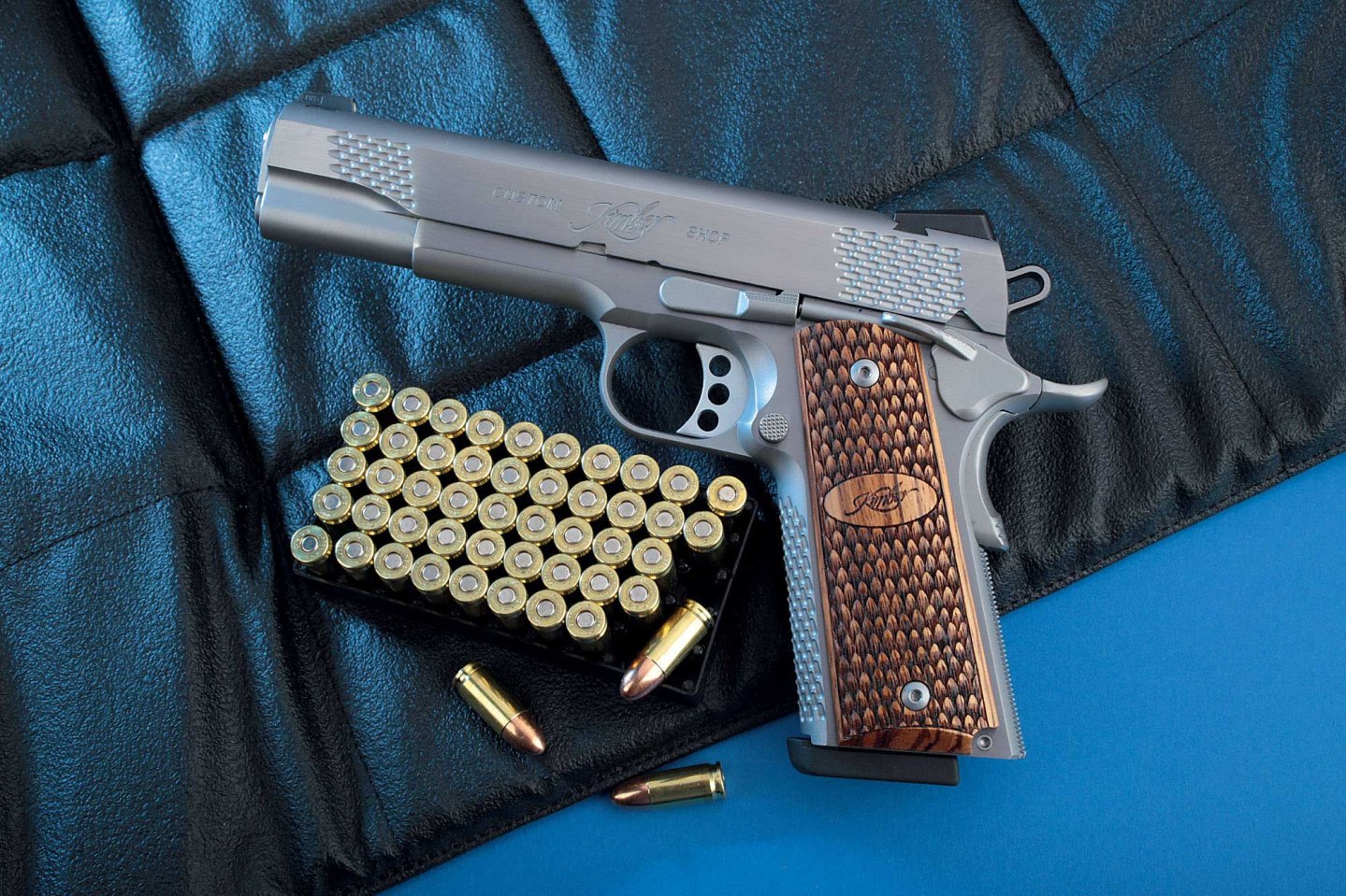 VISIER 11/2016 Kimber STS Raptor II in linker Seiteansicht auf einer schwarzen Matte neben Munition in 9mm Luger.