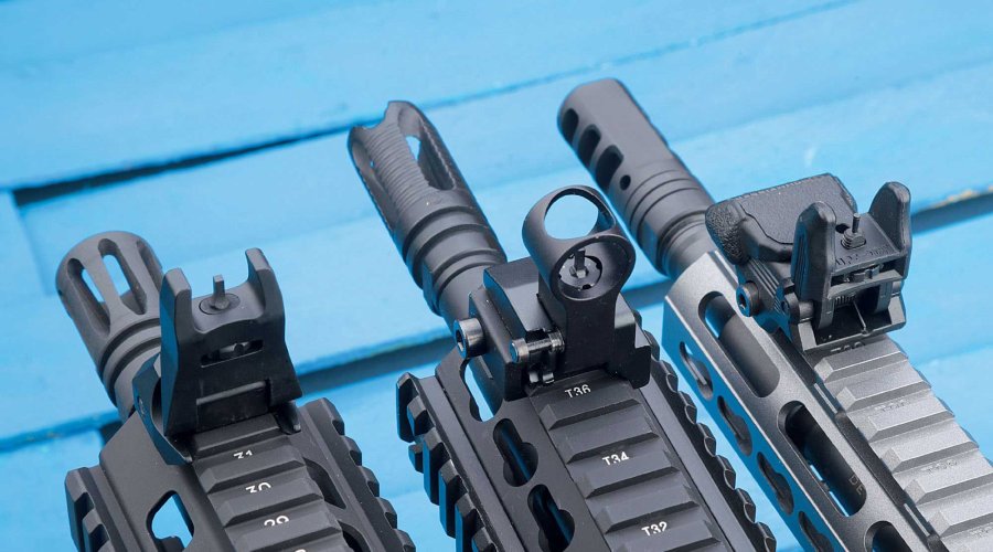 VISIER 8/2017 Drei Gewehrmündungen mit Kornen auf Picatinny-Schienen über blauem Untergrund.