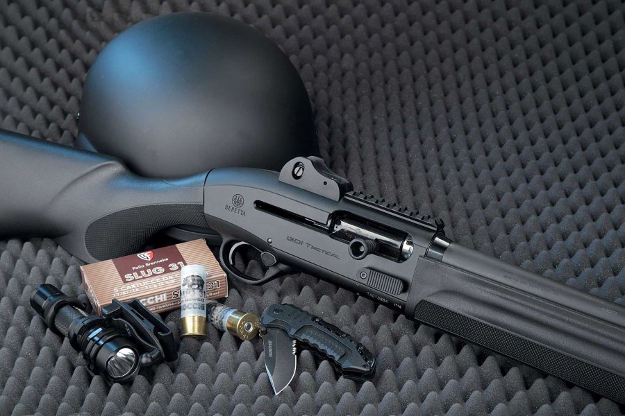VISIER 9/2016 Beretta 1301 Tactical mit 12/76-Schrotpatronen, Messer, Taschenlampe und Helm auf grauem Schaumstoff.