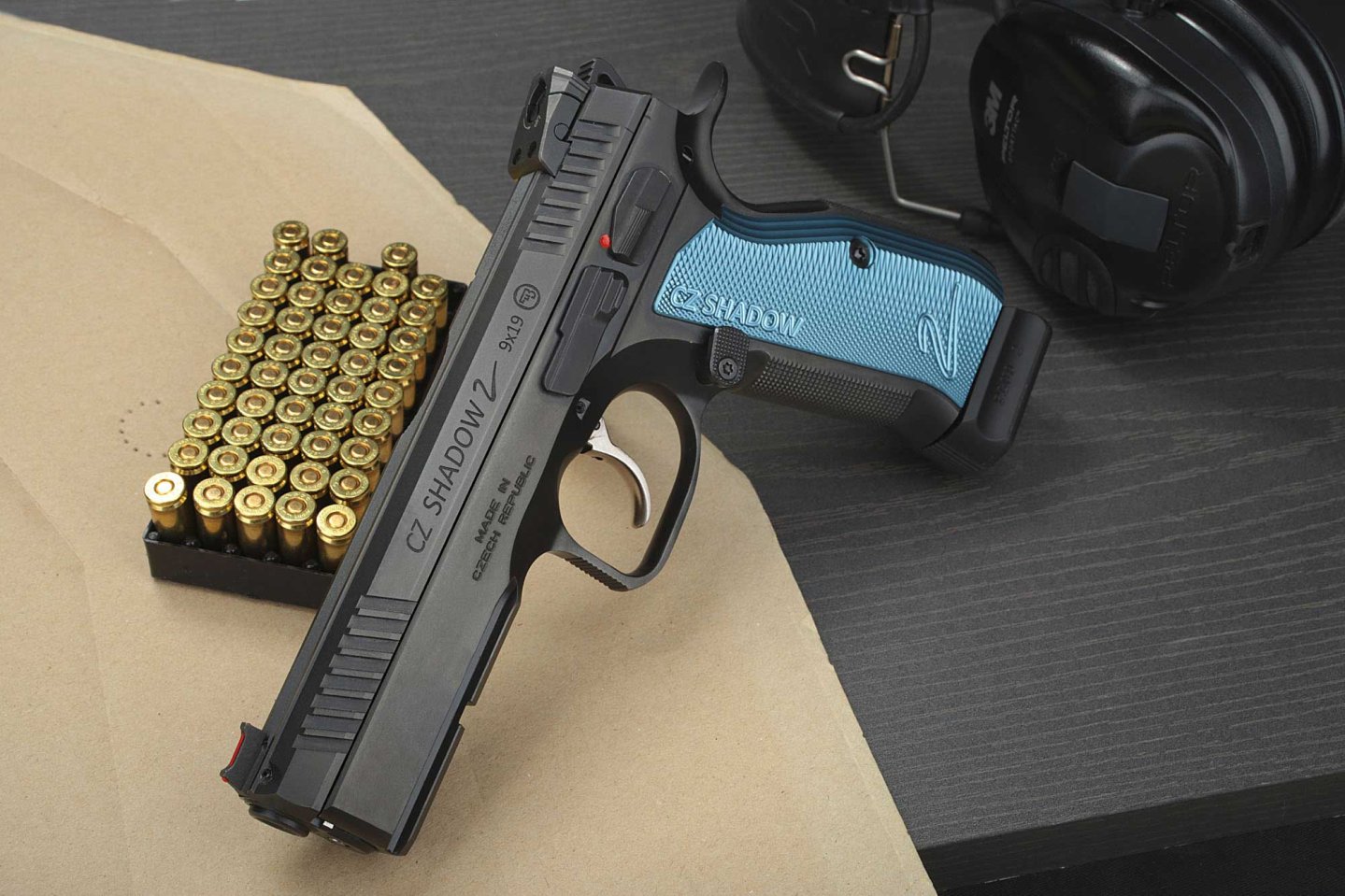 VISIER 10/2016 CZ Shadow 2 auf 9mm-Luger-Muntion auf Zielscheibe neben einem Gehörschutz.