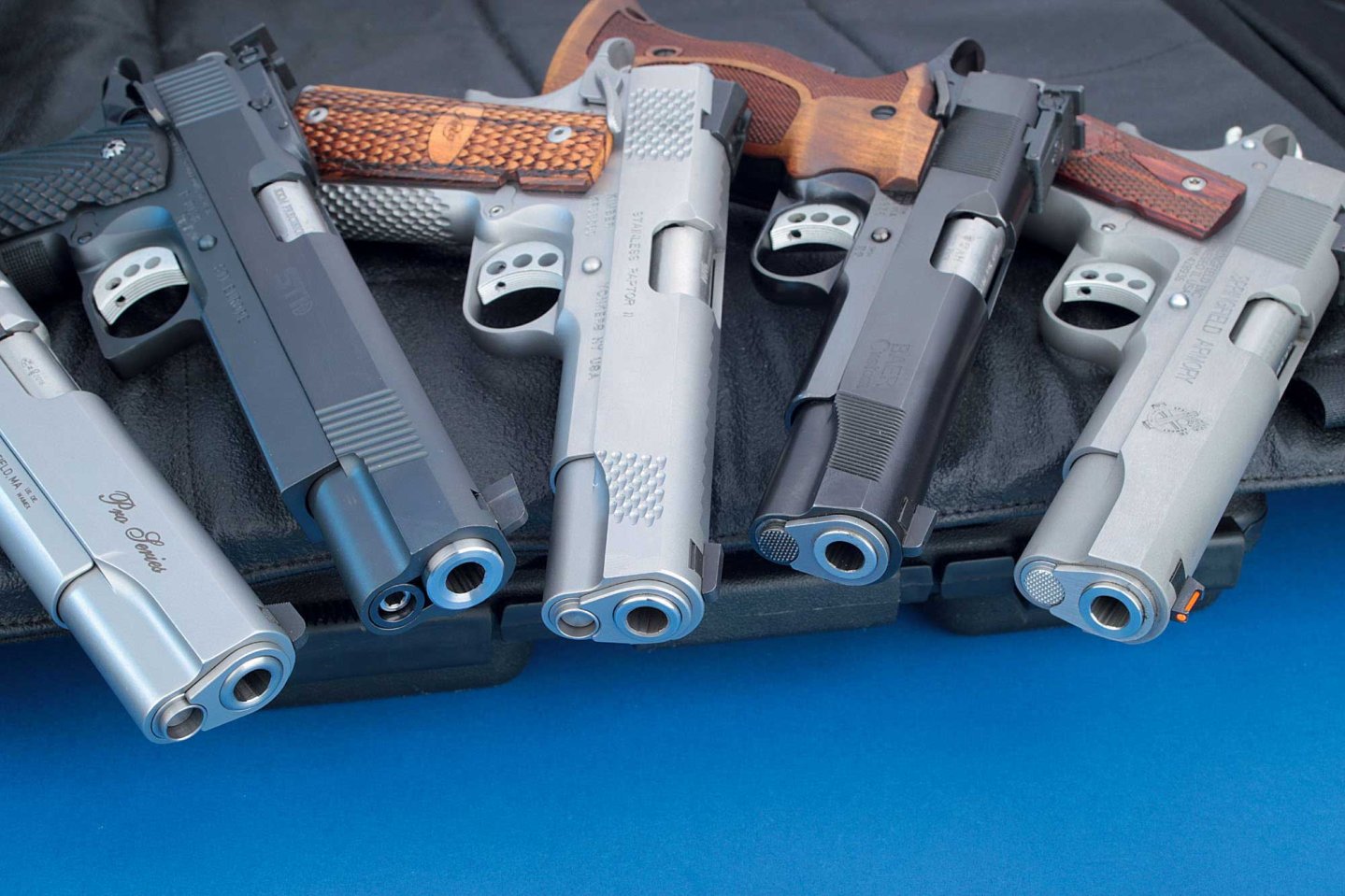 VISIER 11/2016 Fünf Government-Pistolen mit der Mündung nach unten zeigend auf einer Schießmatte.