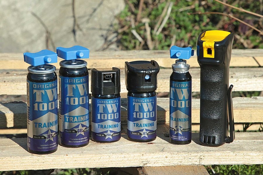 VISIER 5/2017: Mit Trainersprays wie dieser TW 1000-Reihe von Hoernecke lässt es sich realitätsnah üben. Trainersprays von TW100 in verschiedenen Größen und Ausführungen auf einer Holzbank.