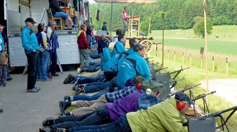 Mehrere Schützen liegen nebeneinander auf einem Schiessstand und bereiten sich auf den Schuss vor.