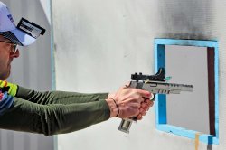 Alles zum IPSC-Schießen kompakt in einem Heft - VISIER Special 82 Schütze zielt mit einem auf einer Pistole befestigten C-More Serendipity Red Dot Sight durch eine rechteckige Öffnung.