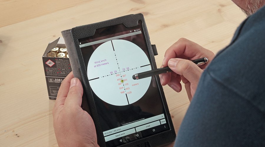 Ein Mann bedient eine Ballistik-App auf seinem Tablet.