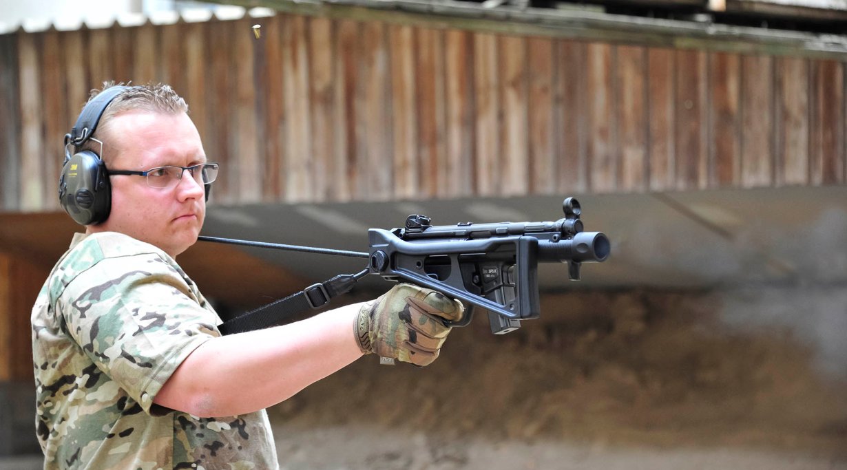 Shooter holding a Heckler & Koch SP5K pistol one-handed