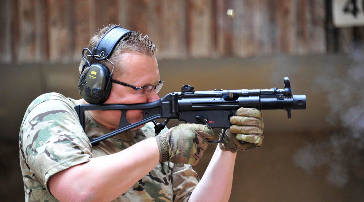 Shooter holding a stocked Heckler & Koch SP5K pistol