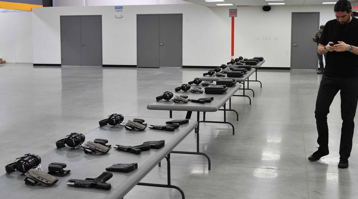 A long table with the SIG Sauer P320 X5 pistols