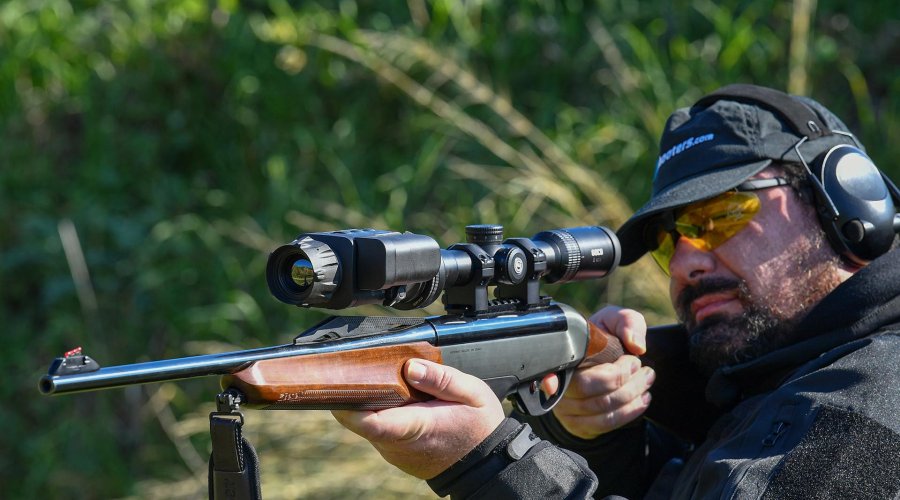 Wielding the firearm with the mounted Chameleon X-Core system in a hunting situation