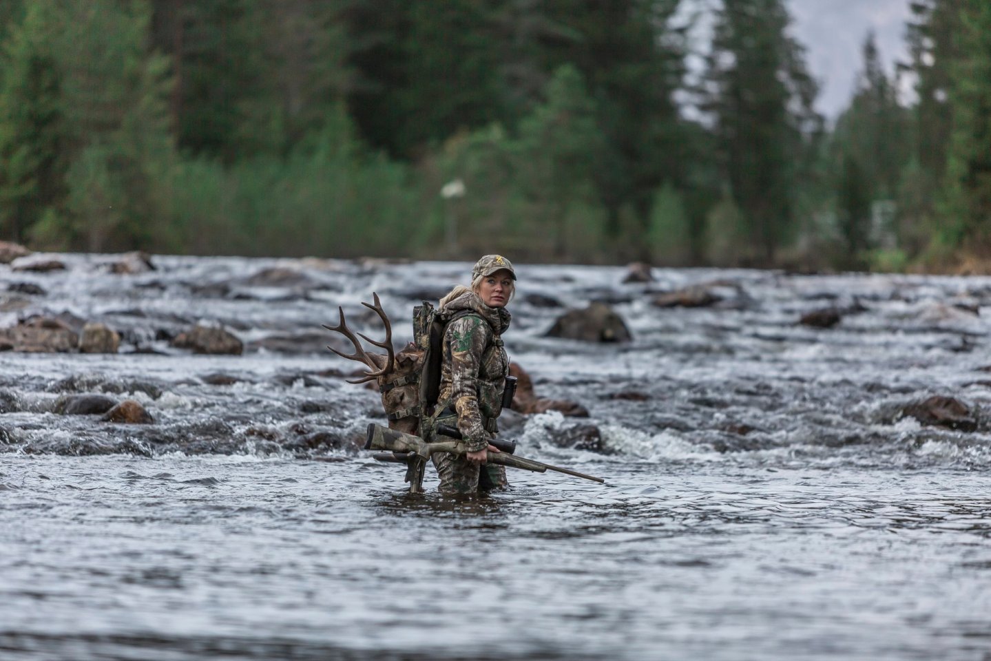 Lise Ailin Lorentzen in a river with her rifle Browning X-Bolt 
