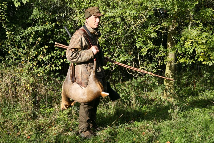 Stalking muntjac by sound Stalker Graham Downing carrying a muntjac over his shoulder.