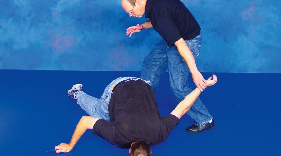 Two men demonstrate the defense to ward off a knife attack with their bare hands. 