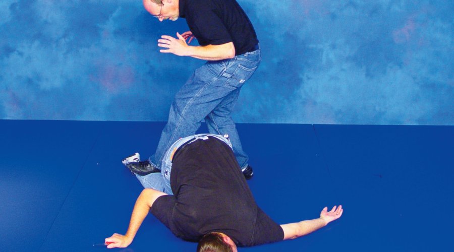 Two men demonstrate the defense to ward off a knife attack with their bare hands. 