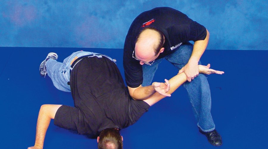 Two men demonstrate the defense to ward off a knife attack with their bare hands. 