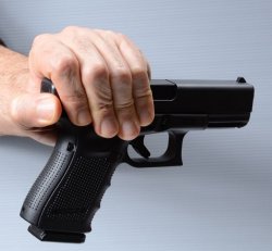 The Tactical Corner – The “round in chamber” dilemma Hand holding a gun