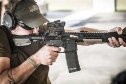 Waffen Ferkinghoff becomes Ferkinghoff International: a change of name on the company's 30th anniversary Shooter shooting with an automatic rifle with Trijicon ACOG 1-5x16 mounted on it.