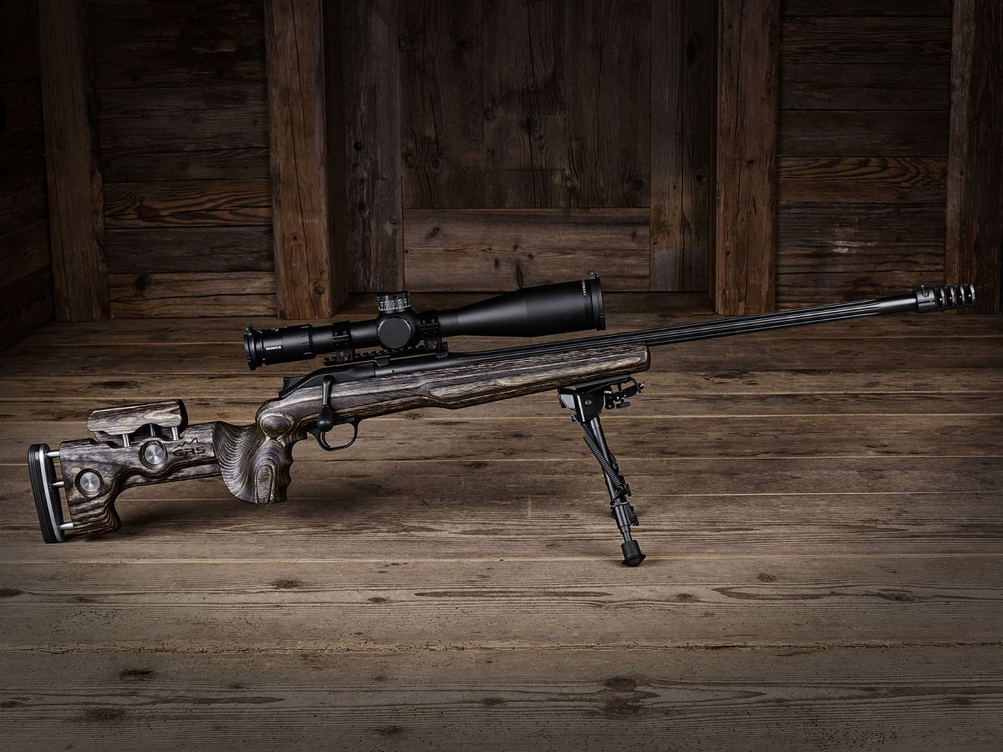 Una carabina Blaser R8 con calciatura GRS Riflestocks su pavimento di legno