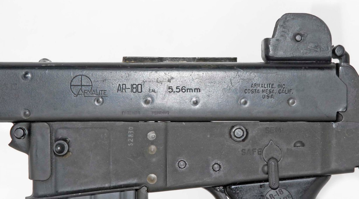 Lato sinistro di un AR-18 prodotto a Costa Mesa e quello del fucile prodotto da Sterling. L'impianto di Costa Mesa era poco più di un'officina pensata per la realizzazione di prototipi: paragonato al fucile Sterling, questo appare assai più grezzo: la piegatura della lamiera è meno precisa, le saldature più rozze e i marchi stampati non sono altrettanto netti. Inoltre, il lamierato del supporto di basculamento frontale sembra privo delle saldature a cordolo di rinforzo e sembra saldato solo per puntatura.