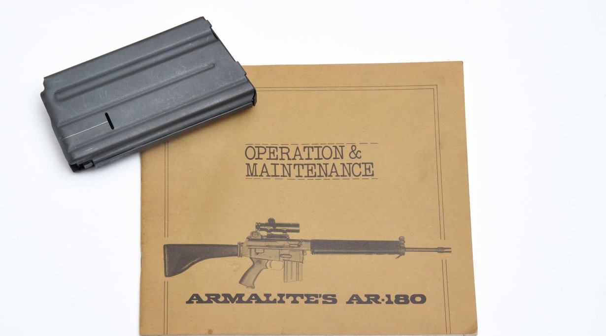 Il libretto d'istruzioni mostra l'arma con la sua ottica. L'uso di un'ottica come sistema di puntamento primario su un'arma militare era un concetto relativamente nuovo quando l'AR-18 vide la luce. Nella foto, anche un raro caricatore originale per lo AR-18